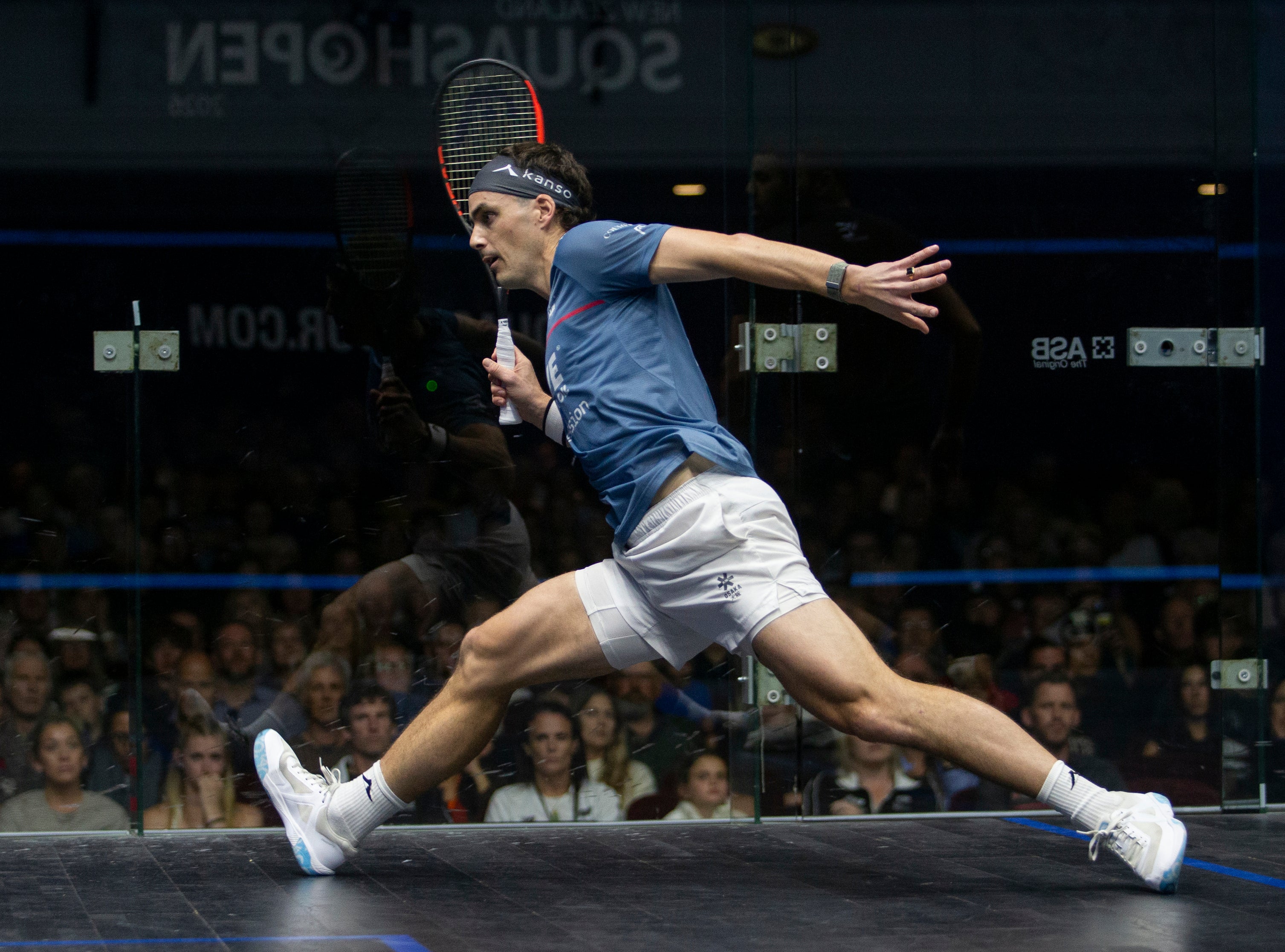 Paul Coll Superman 2026 limited edition squash shirt – NZ pride, XTPro performance fabric Provincial Blue at full stretch reaching for a ball 