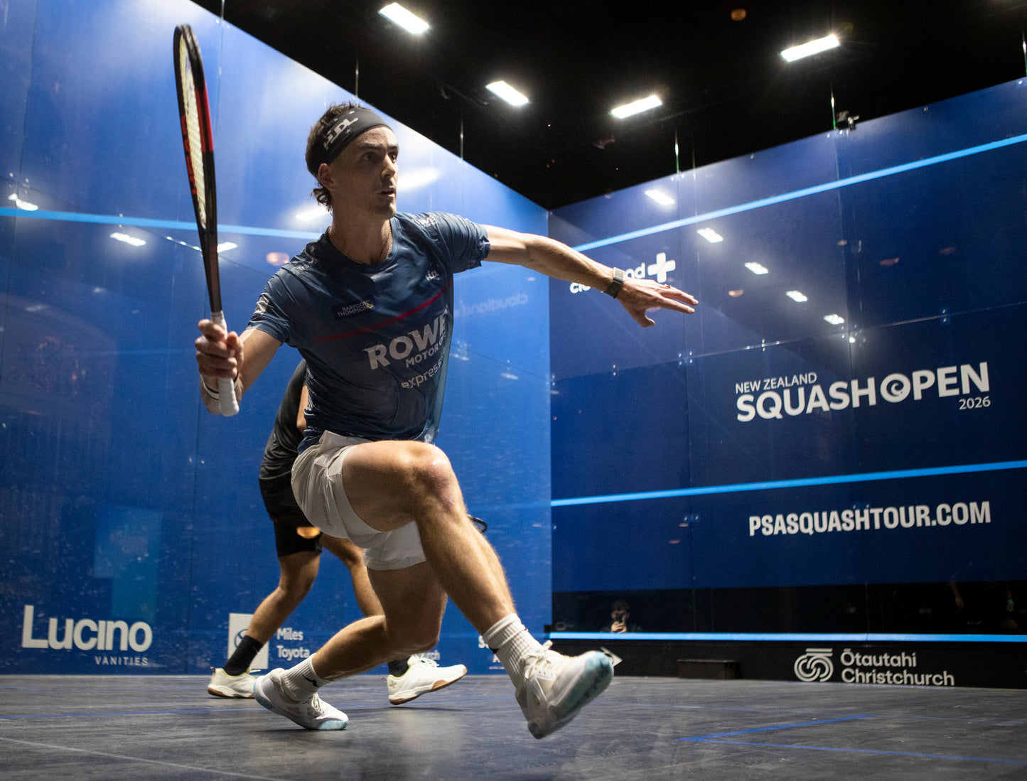 Paul Coll  in action during a match at the New Zealand Squash Open 2026 event.  Wearing his Superman Provincial Blue Tournament T shirt