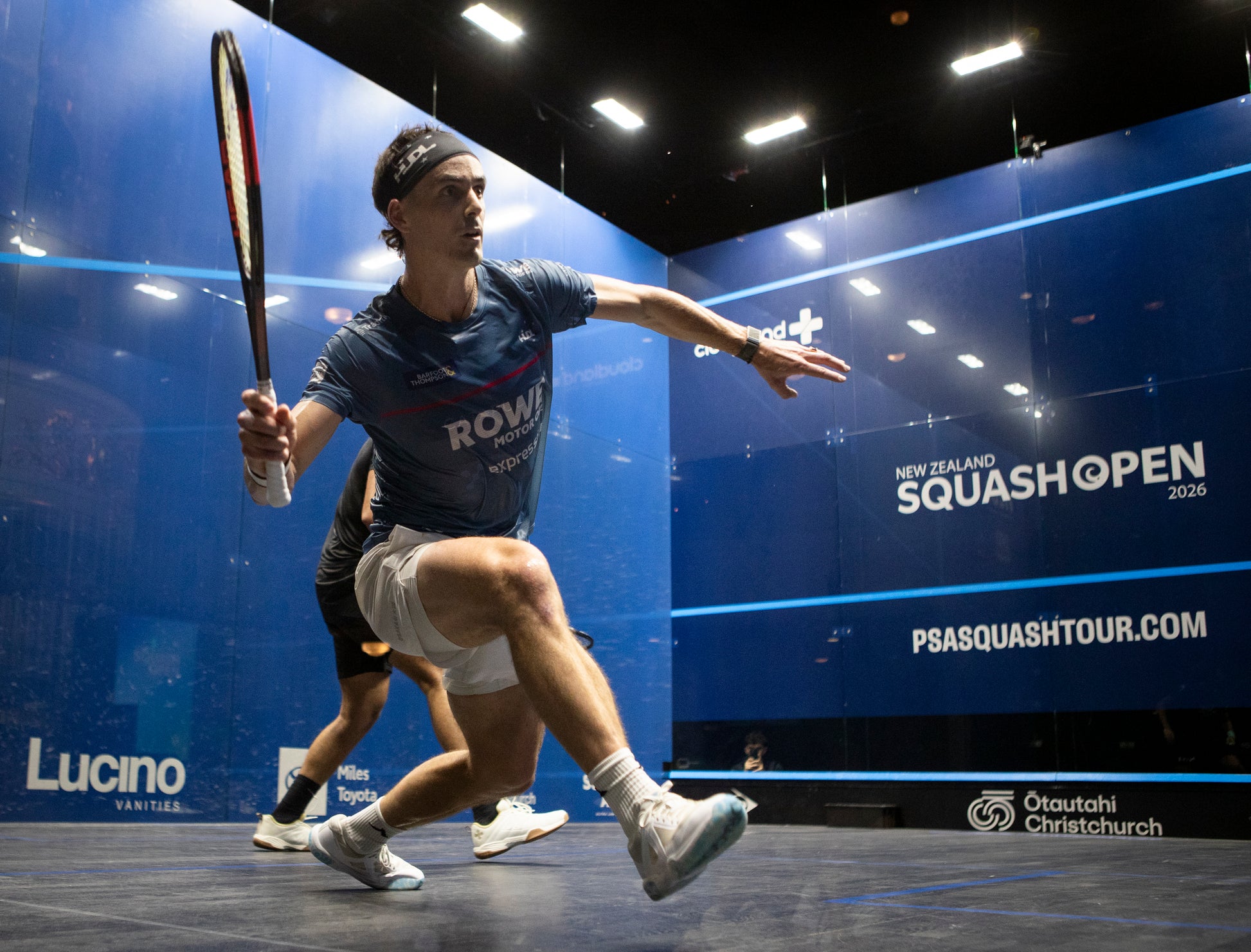 Paul Coll  in action during a match at the New Zealand Squash Open 2026 event.  Wearing his Superman Provincial Blue Tournament T shirt