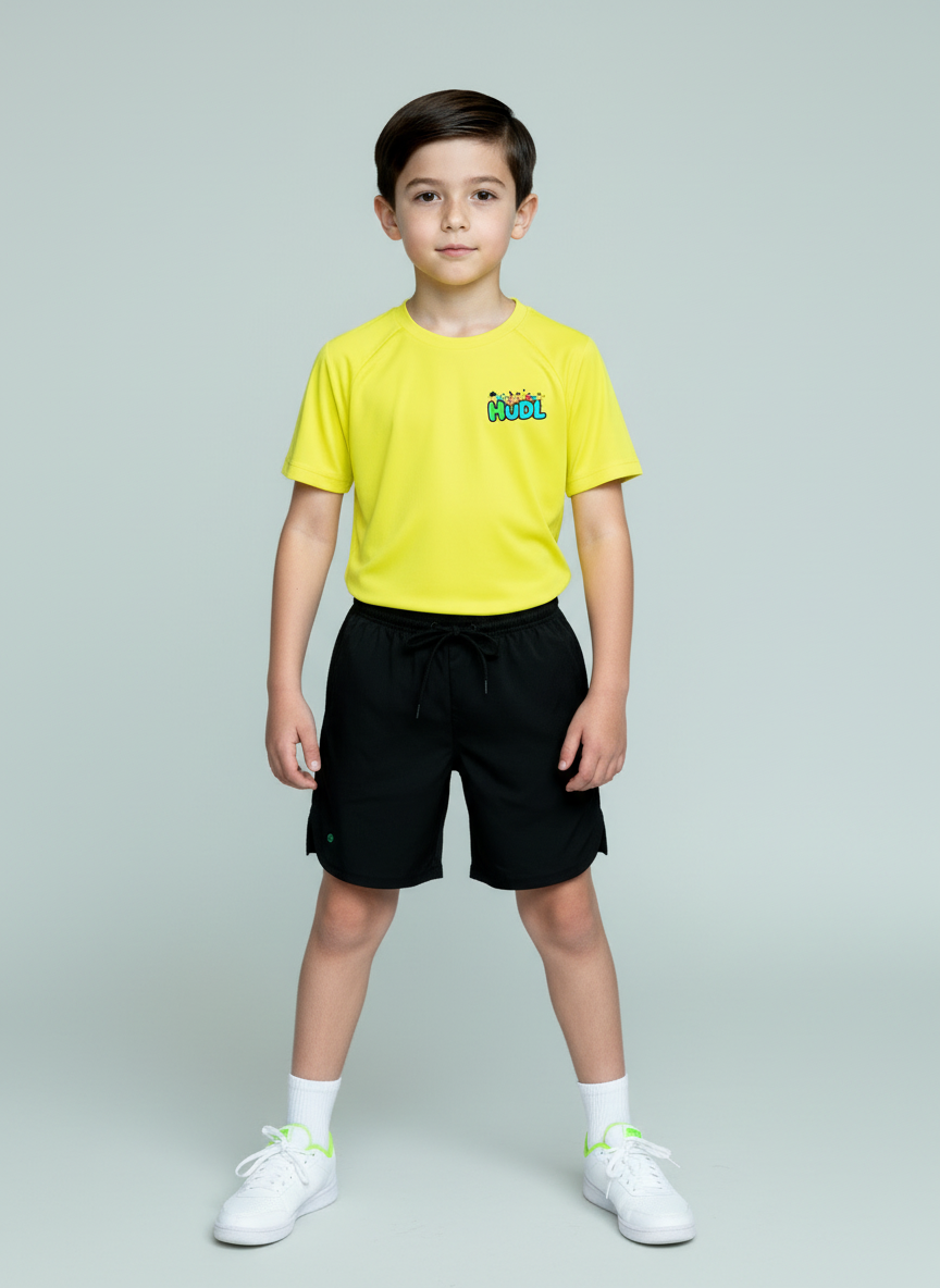 A young boy standing in a yellow HUDL kids squash performance T-shirt – XTPro fabric, wicking and light weight, junior fit