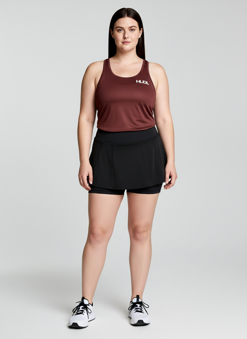 A woman standing wearing HUDL women's scoop neck squash training top – XTPro fabric, breathable racer-back design in red 