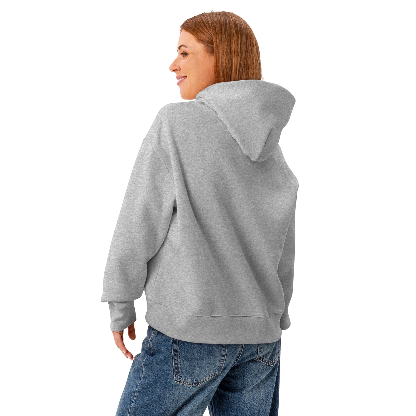 A woman standing wearing a HUDL women's relaxed fit pullover hoodie – off-court squash style, embroidered logo in athletic heather