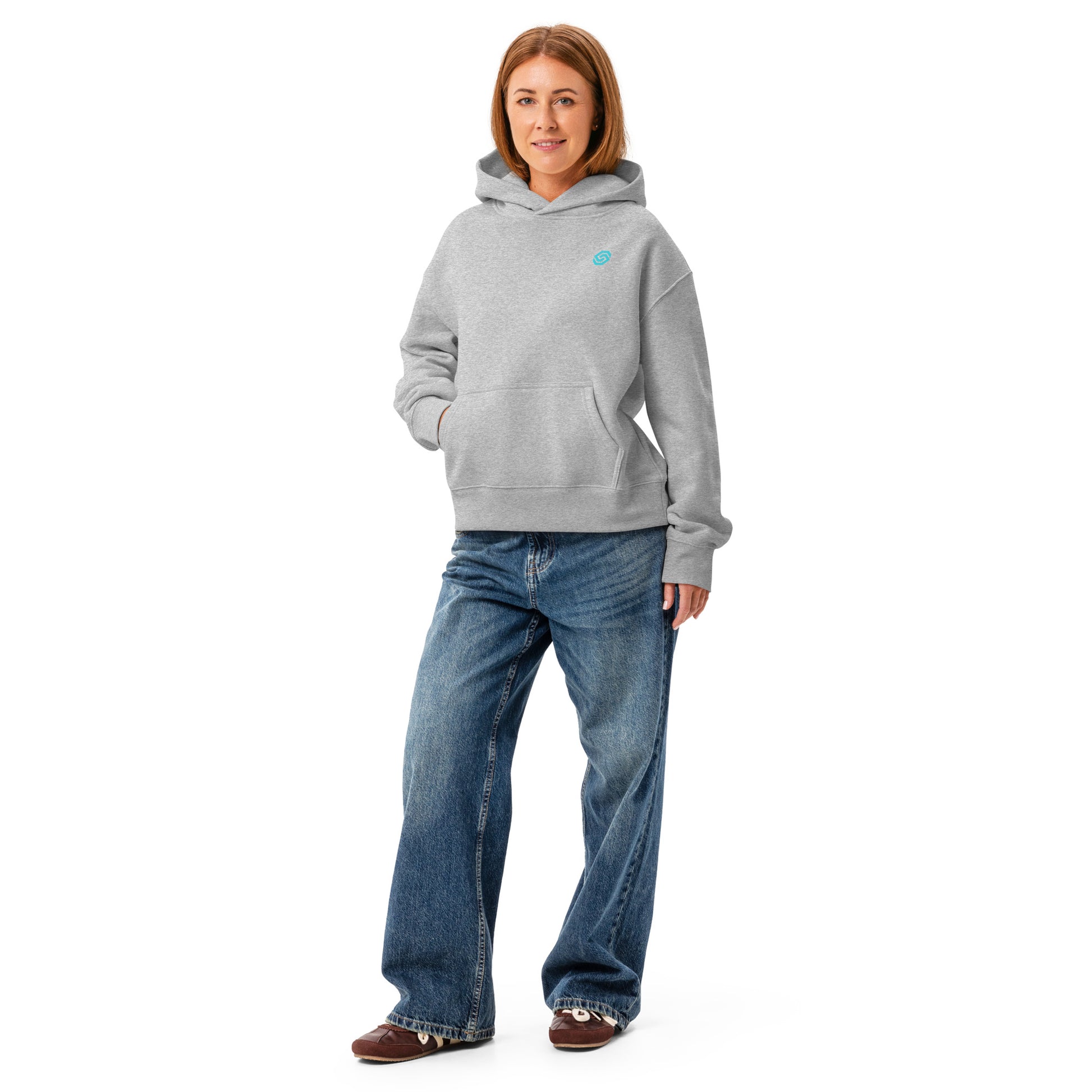 A woman wearing a HUDL women's relaxed fit pullover hoodie – off-court squash style, embroidered logo in athletic heather