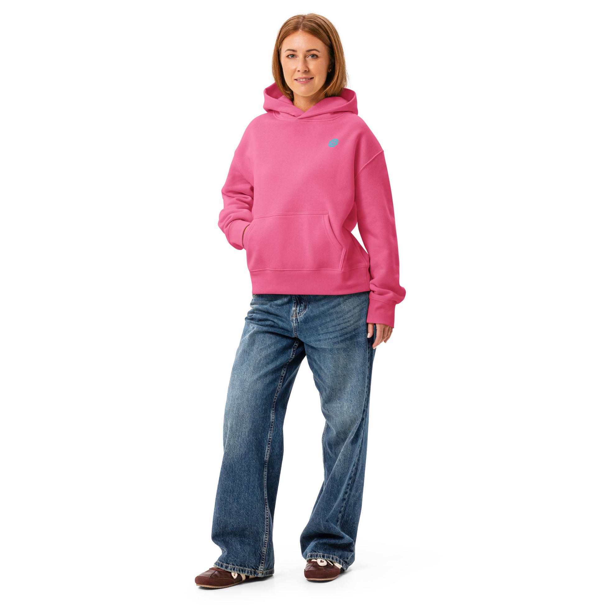 A woman wearing a HUDL women's relaxed fit pullover hoodie – off-court squash style, embroidered logo in charity pink