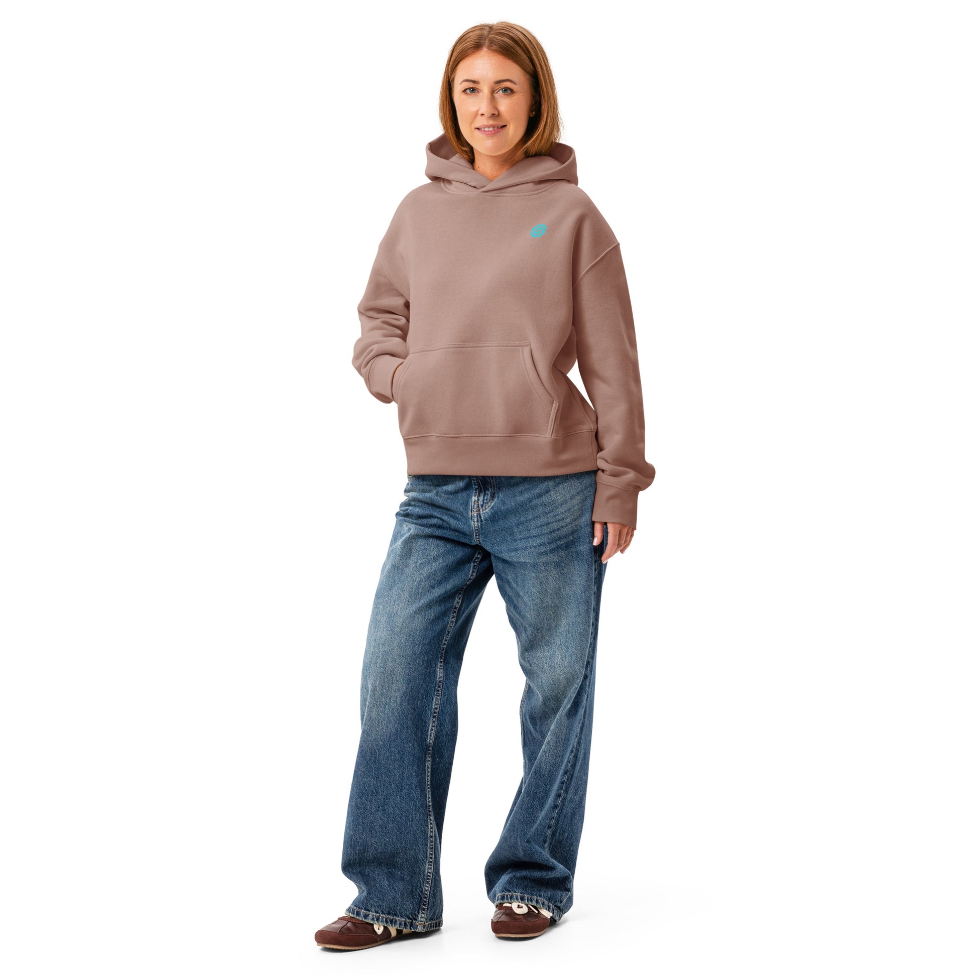 A woman wearing a HUDL women's relaxed fit pullover hoodie – off-court squash style, embroidered logo in hazy pink