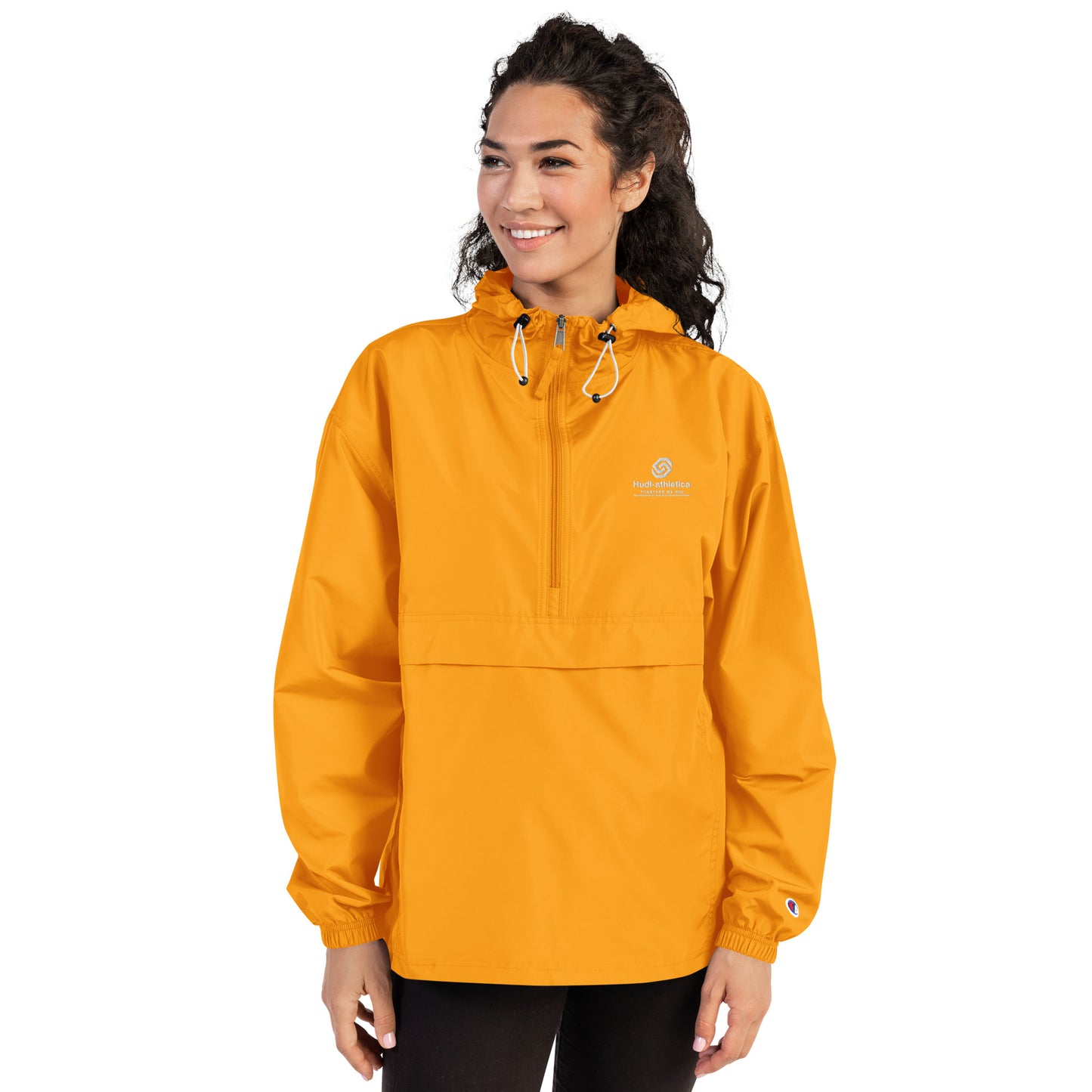 A woman wearing the HUDL lightweight packable windbreaker jacket – squash warm-up gear, embroidered logo in yellow