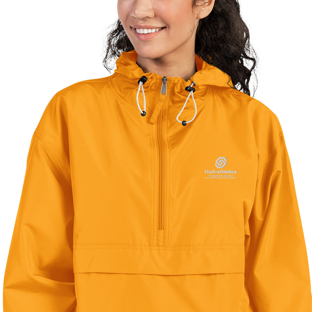 A close up of a woman wearing the HUDL lightweight packable windbreaker jacket – squash warm-up gear, embroidered logo in yellow