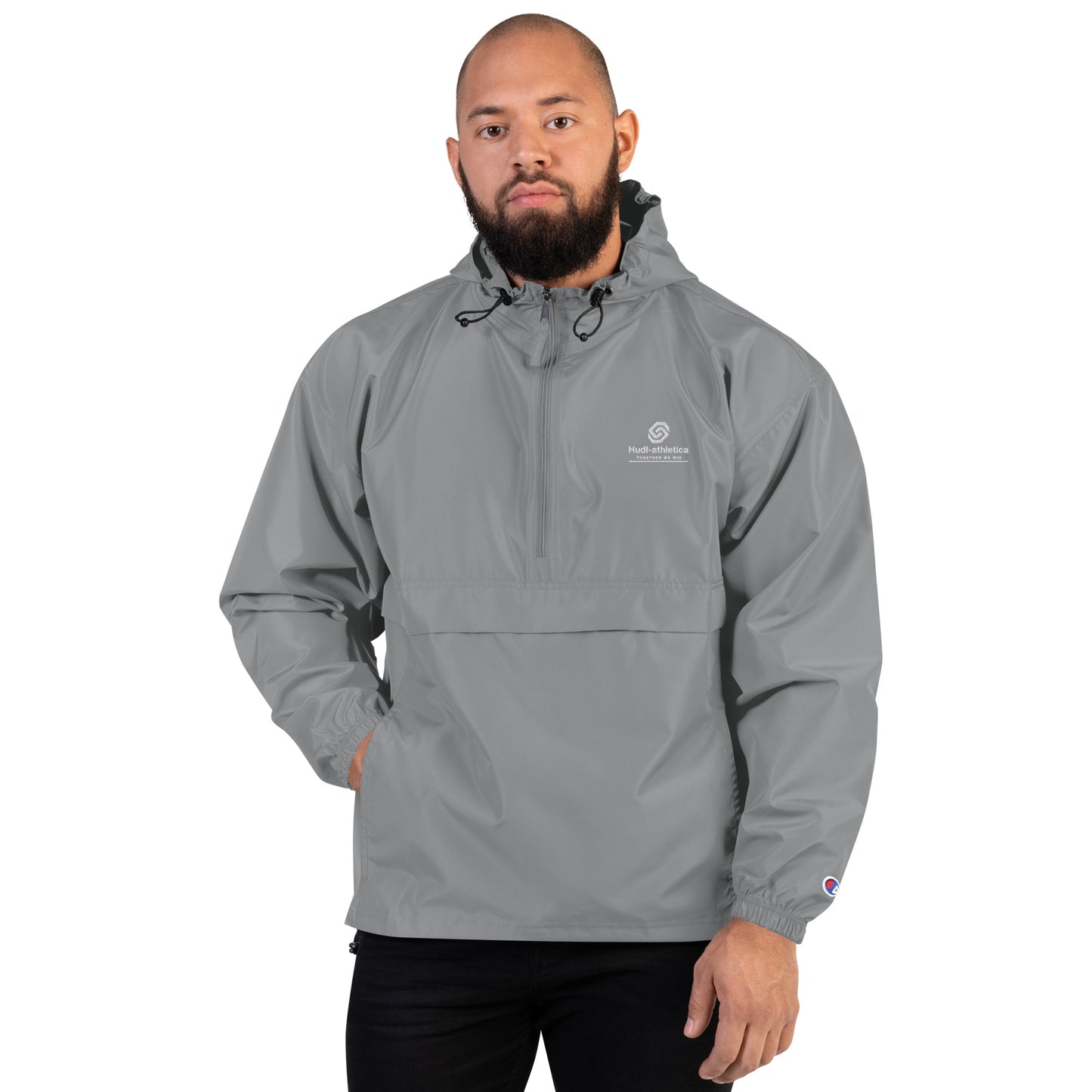 A man wearing the HUDL lightweight packable windbreaker jacket – squash warm-up gear, embroidered logo in grey