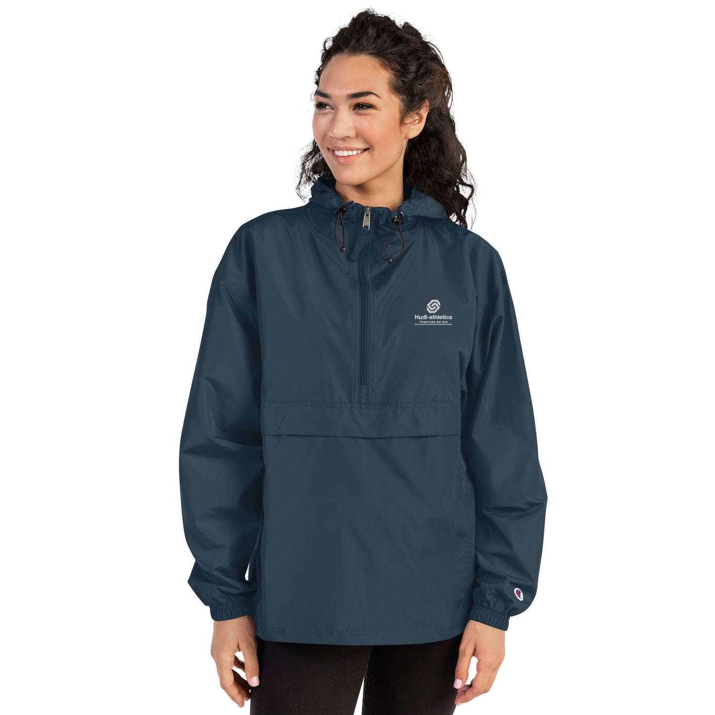A woman wearing the HUDL lightweight packable windbreaker jacket – squash warm-up gear, embroidered logo in navy