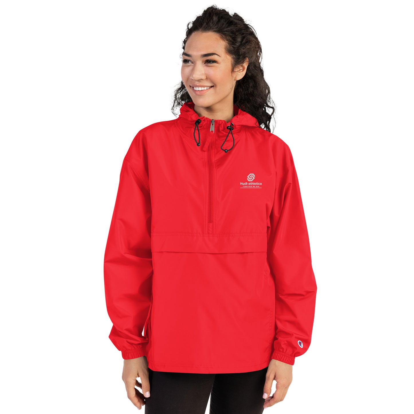 A woman wearing the HUDL lightweight packable windbreaker jacket – squash warm-up gear, embroidered logo in red