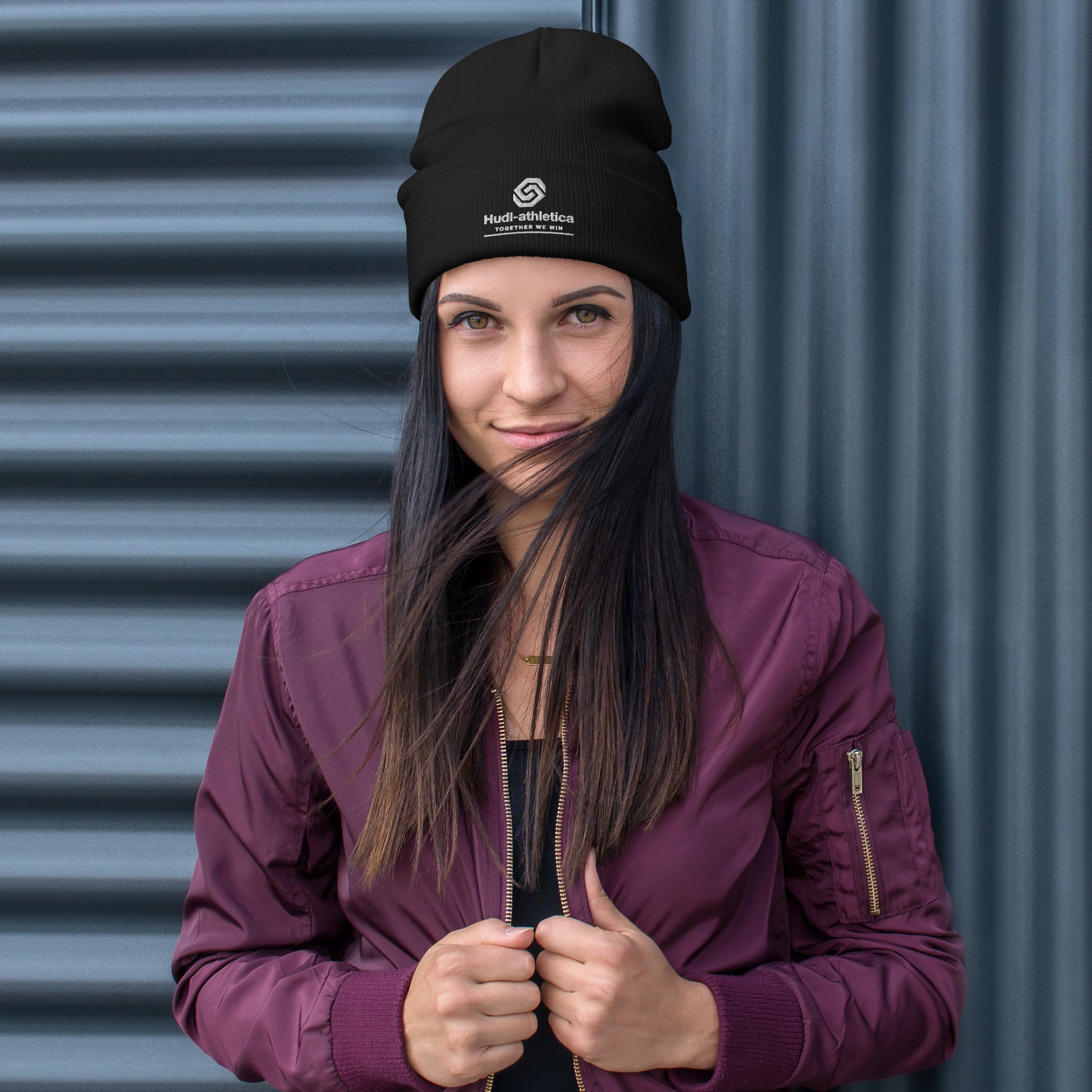 A woman wearing a HUDL embroidered knit beanie – squash community streetwear, warm and stylish off-court in Black
