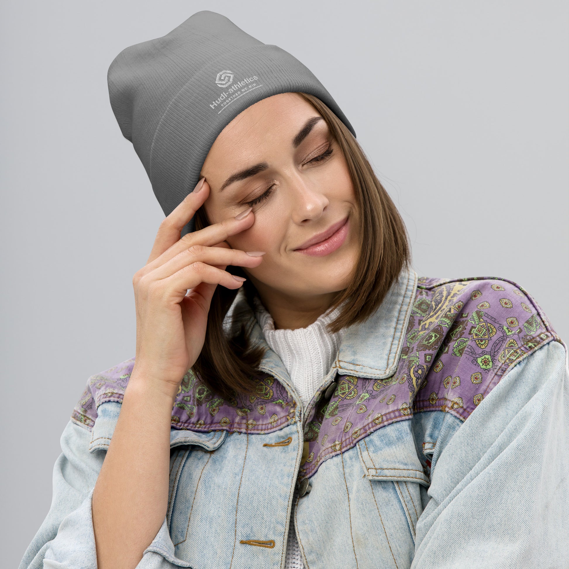 A woman wearing a HUDL embroidered knit beanie – squash community streetwear, warm and stylish off-court in grey