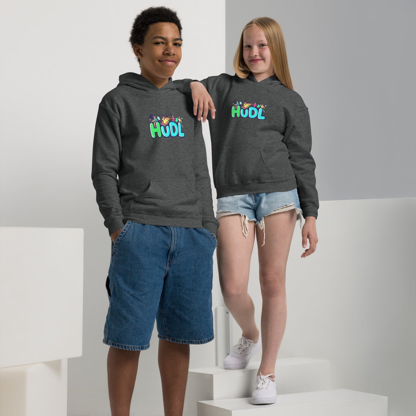 A boy and a girl standing and wearing a HUDL youth heavy blend hoodie – warm, durable off-court hoodie for junior squash players in grey 