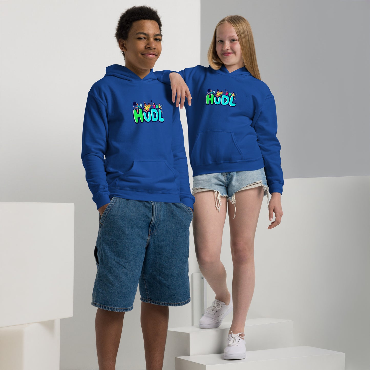 A boy and a girl standing and wearing a HUDL youth heavy blend hoodie – warm, durable off-court hoodie for junior squash players in royal blue 